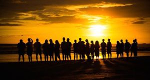 GROUP LINE AT SUNSET ON PLAYA GUIONES